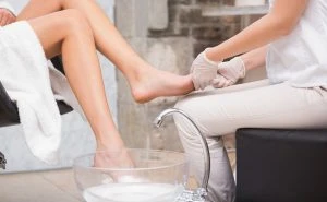 Woman getting a pedicure from beautician