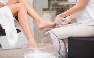 Woman getting a pedicure from beautician