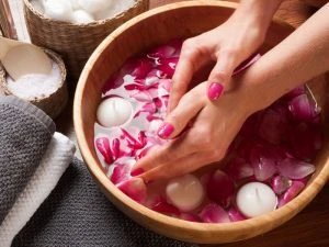 handen in water met rozenbladen